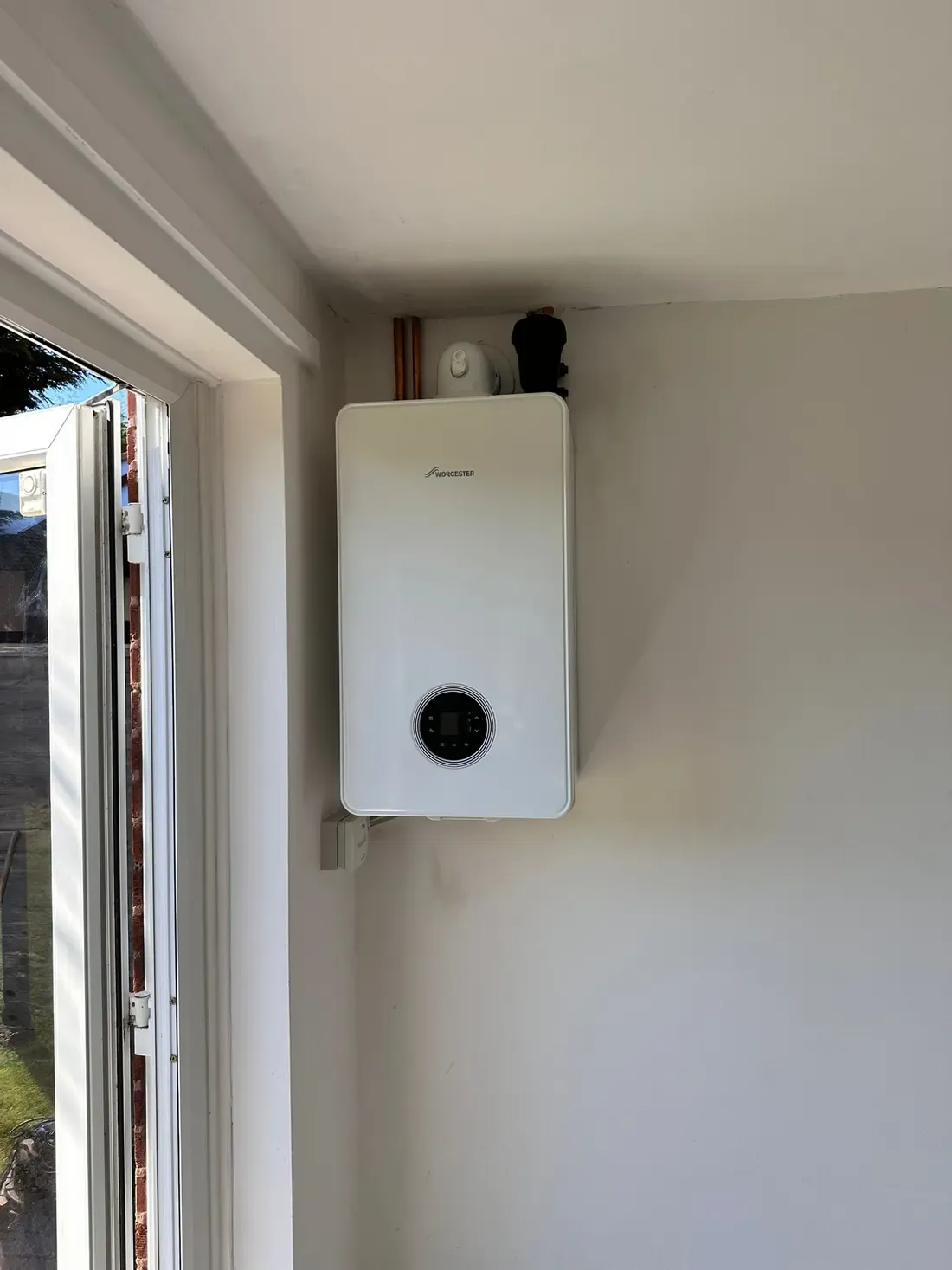 Worcester Bosch combi boiler installed beside a utility room doorway